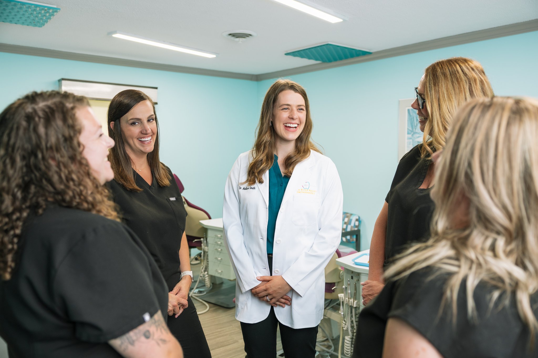 An orthodontist smiling with a group of team members during a branding session in Tampa, FL.
