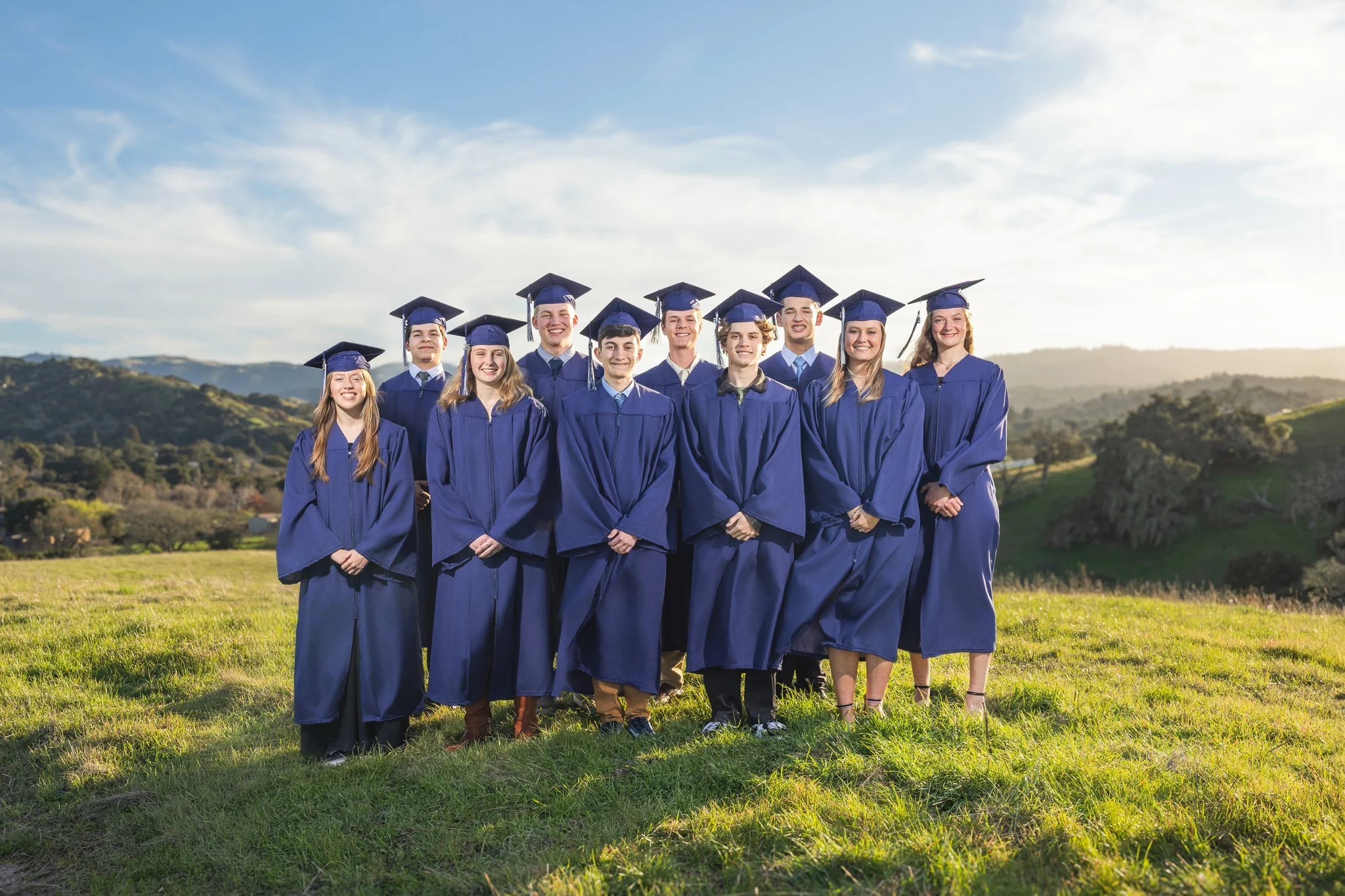 A group of seniors dressed in cap and gowns for a group photo during a Tampa, FL senior photo session.