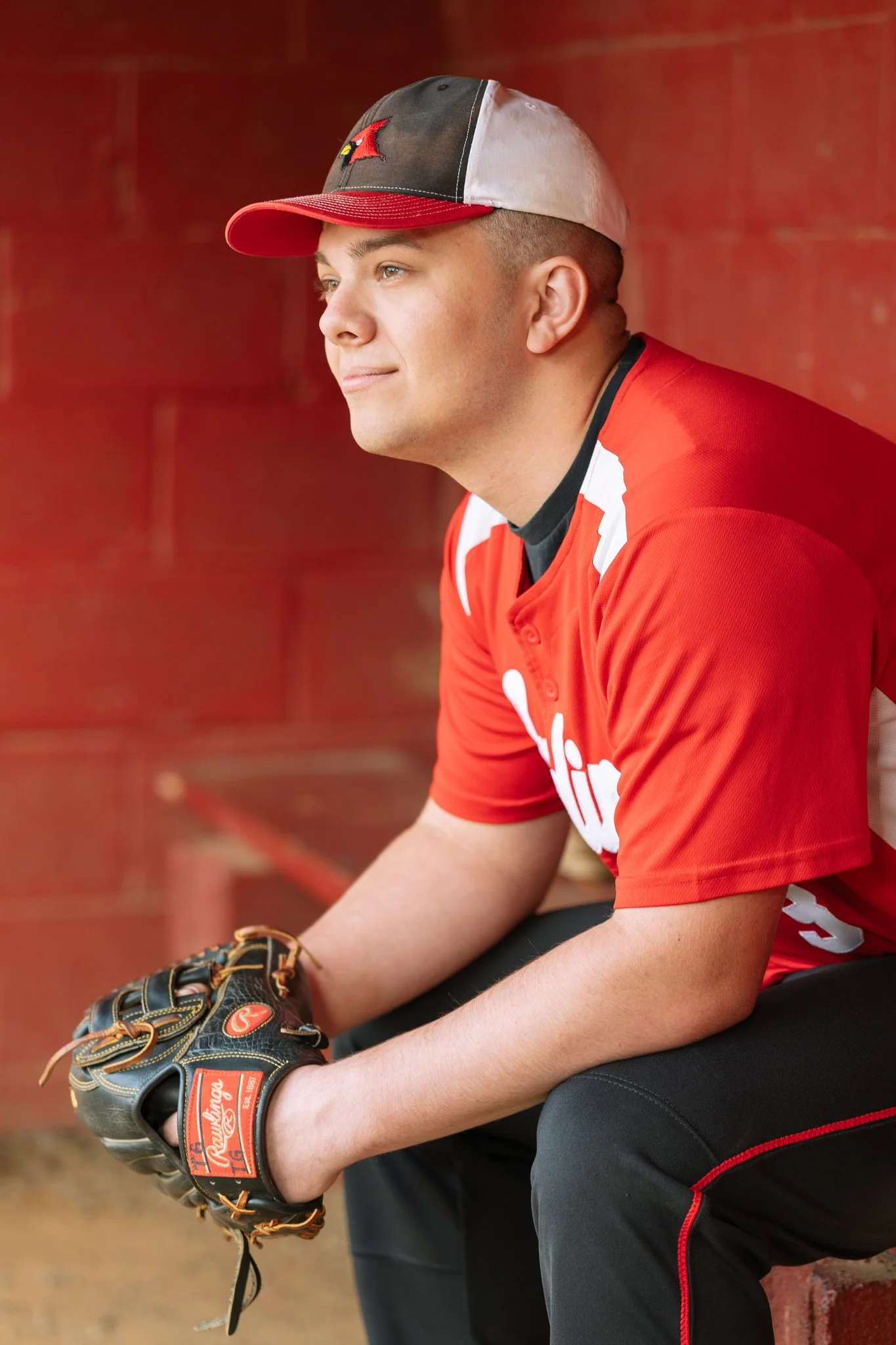 A senior graduate posing for a senior photo session in Tampa, FL wearing his baseball uniform.
