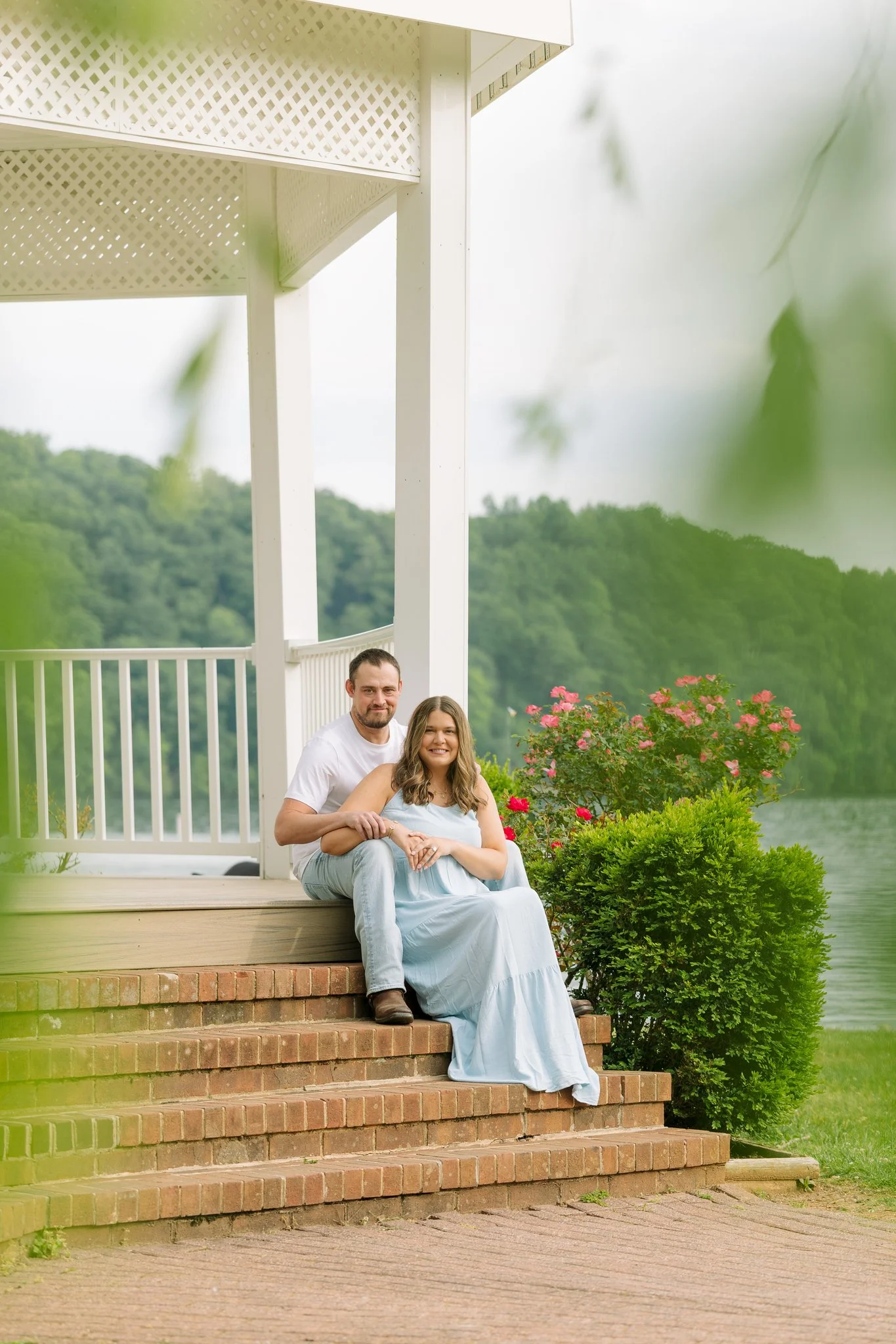 A couple sitting at a gazebo, smiling, for a engagement photo session in Tampa, FL.