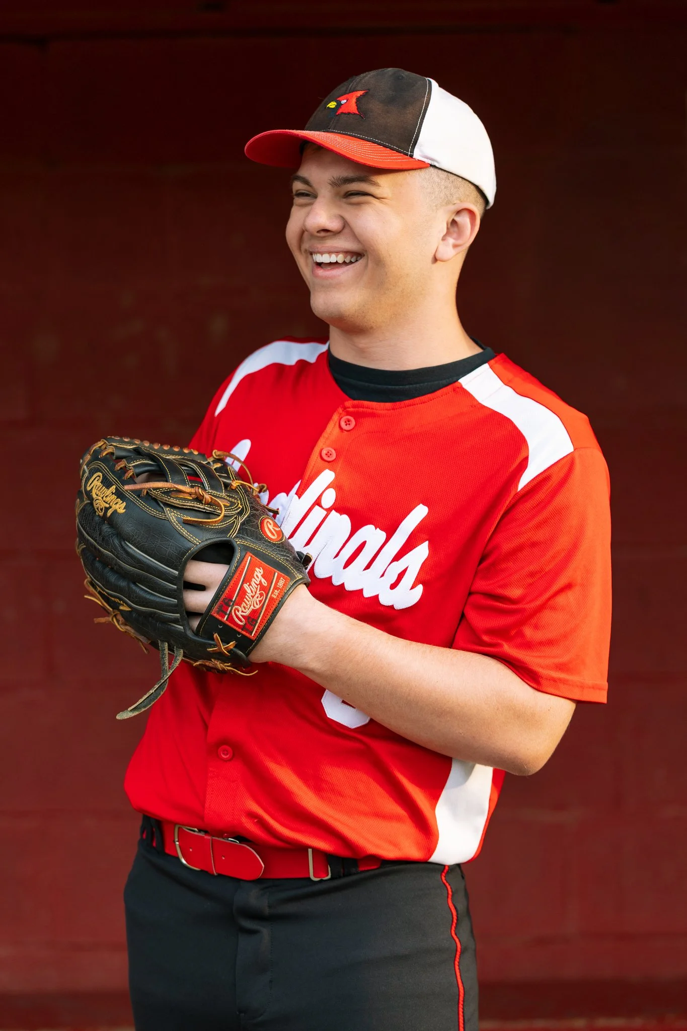 A male senior graduate laughing during a senior portrait session in Tampa, FL.