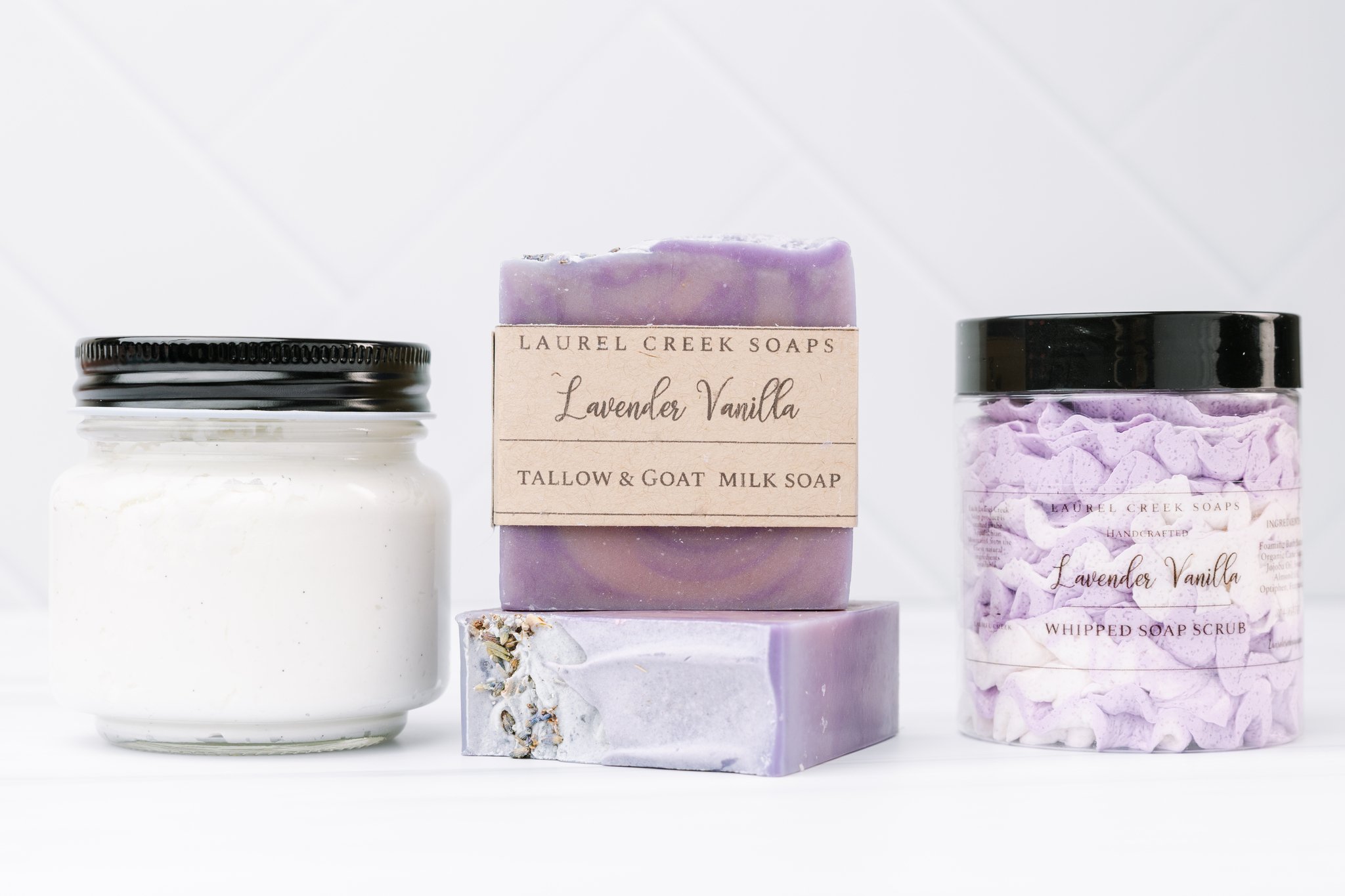 Laurel Creek Soaps Lavender Vanilla soap bar with whipped soap scrub and a glass jar on white tile
