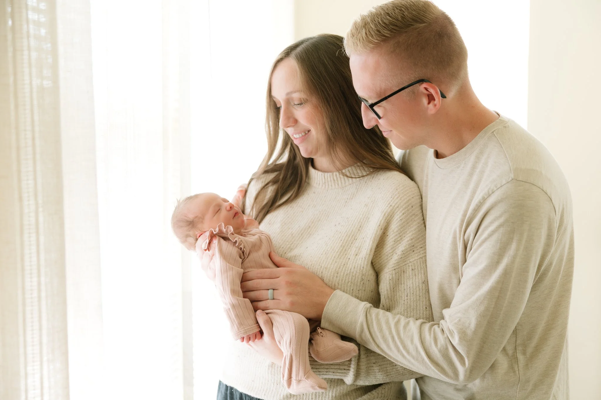 Mom and dad holding their newborn baby in their home during a Tampa, FL at-home newborn session