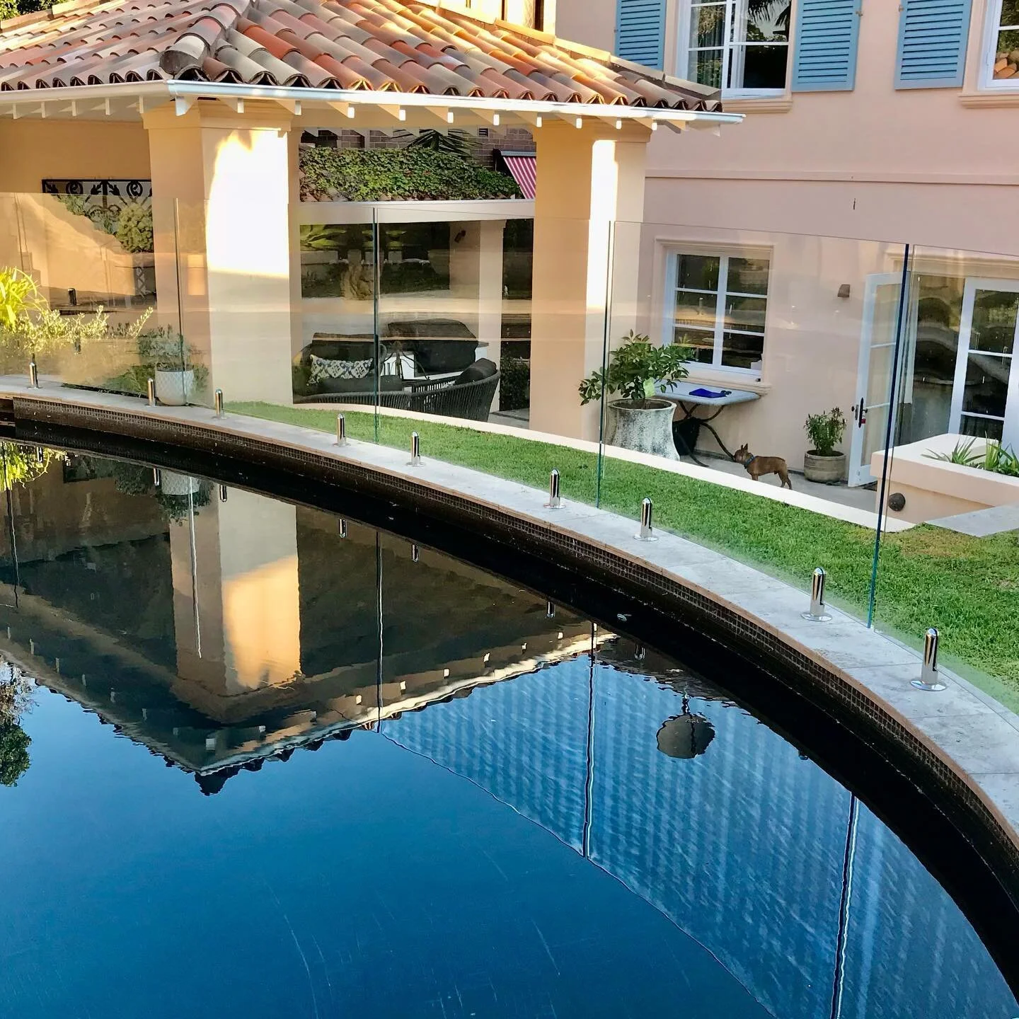 This curved pool fence is a beautiful solution to a garden with constricted movement through the space where an old linear pool fence was blocking access to the rear of the garden. Individually templated curved panels make the pool a feature rather t