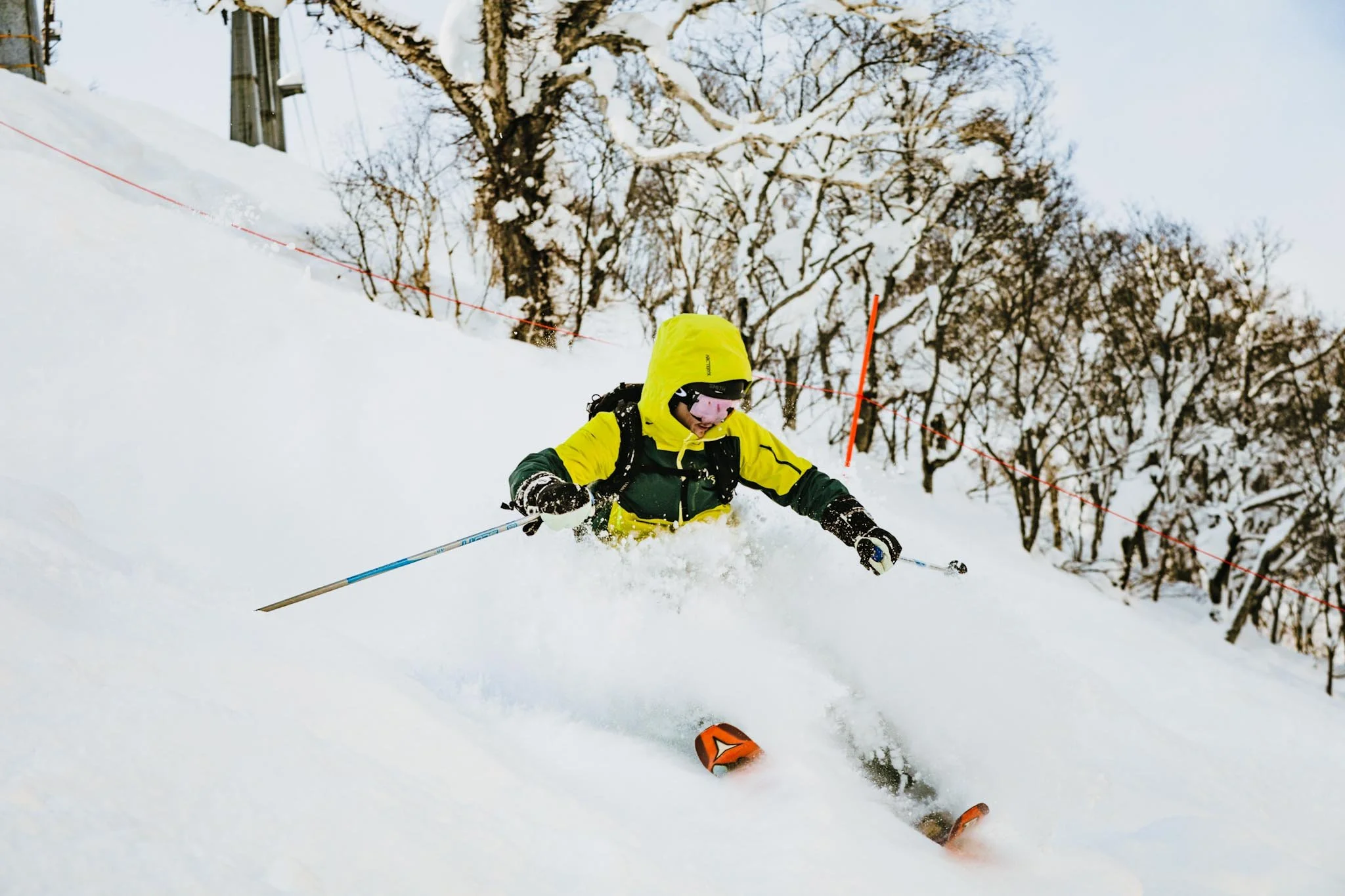 Private ski lesson in Niseko with instructor guiding a skier through fresh powder snow.