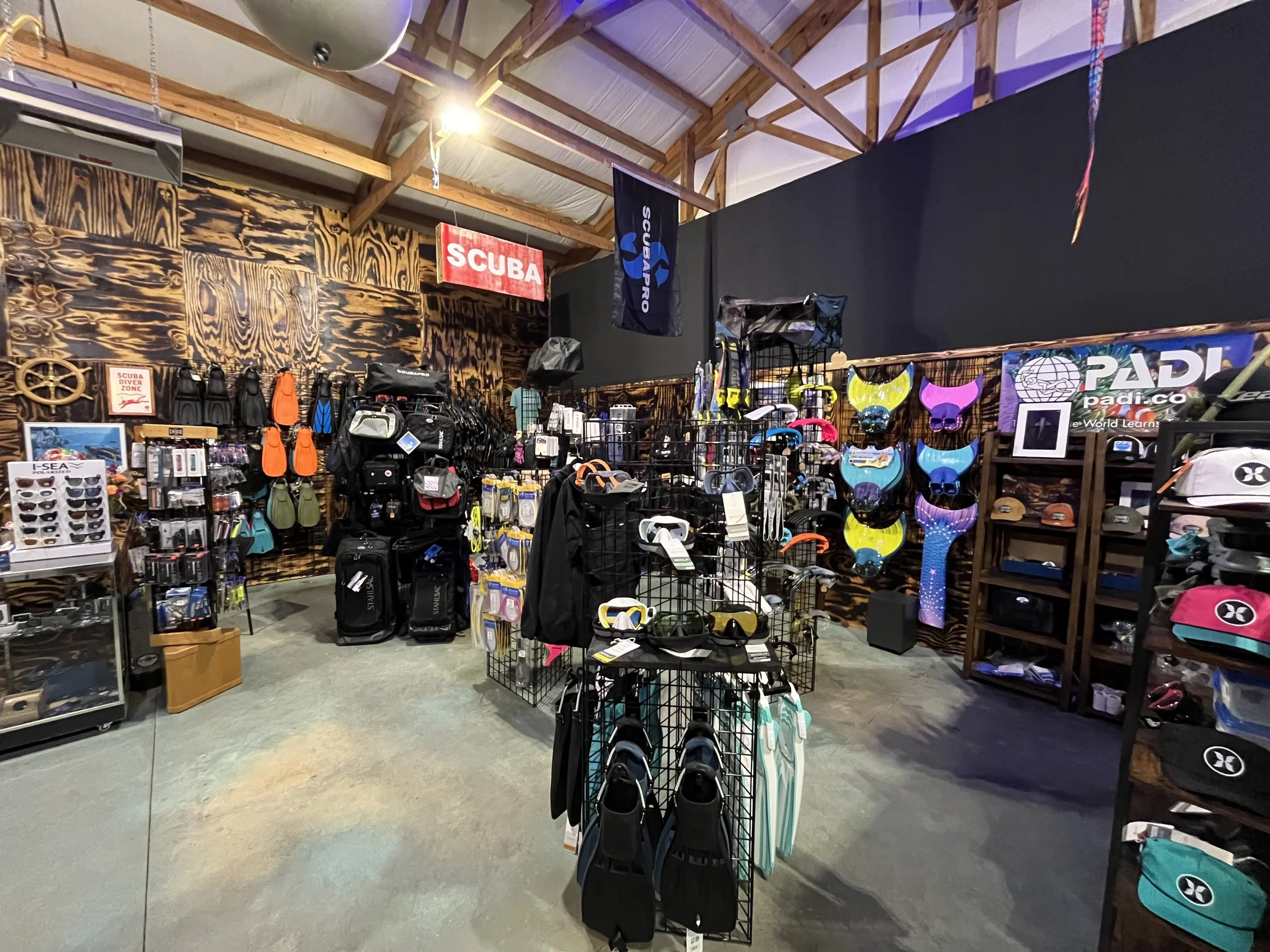 Dive shop interior with scuba gear, accessories, and equipment on display, including masks, fins, and snorkels.