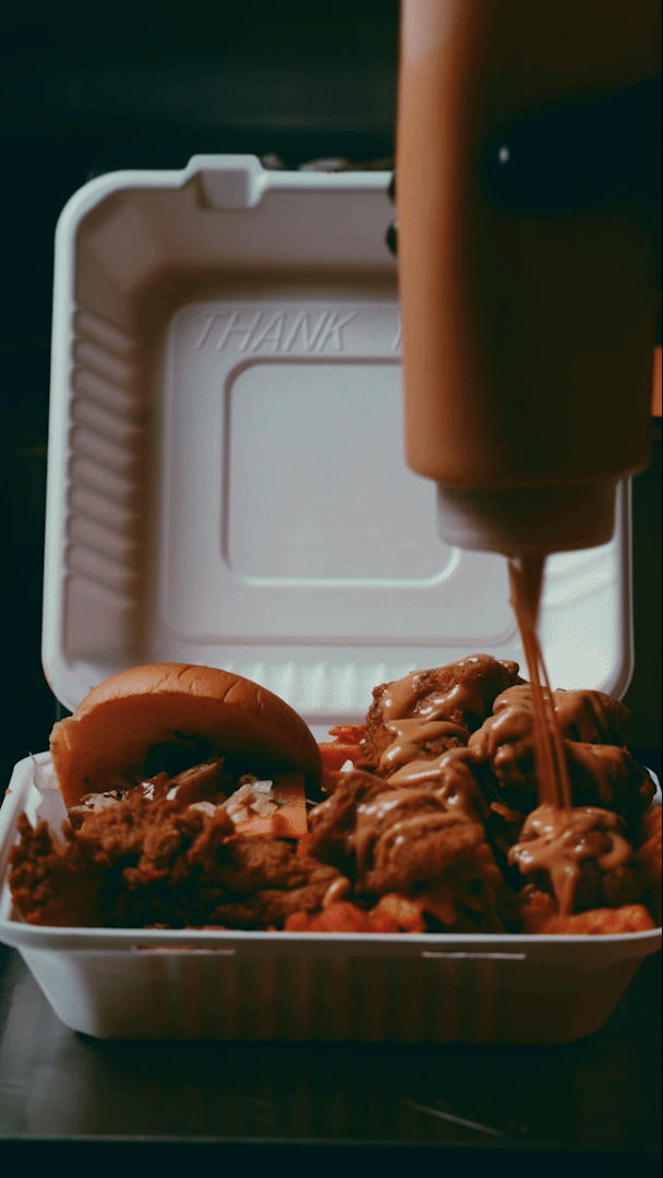 Live action footage of sauce being dispensed onto fried chicken, the Charlie's Chicken logo appears as if hand written over the top.