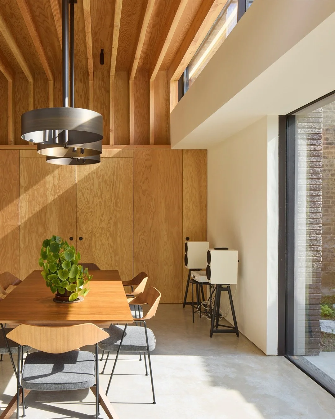 UP AND OVER

The extension is designed as an exposed Douglas Fir structure supporting a flat roof. The beams wrap &lsquo;Up and Over&rsquo; the kitchen space and the roof floats clear about the external walls. This allowed us to insert a strip of hig