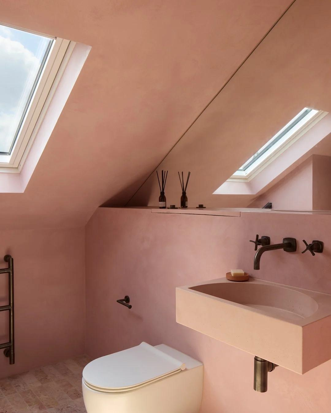 UP AND OVER

The bathrooms are all treated in Tadelakt to add texture and a subtle sheen to the walls, and to create a seamless finish through the room. The smaller loft bathroom has a blush pink finish on the walls and ceilings, with a matching conc