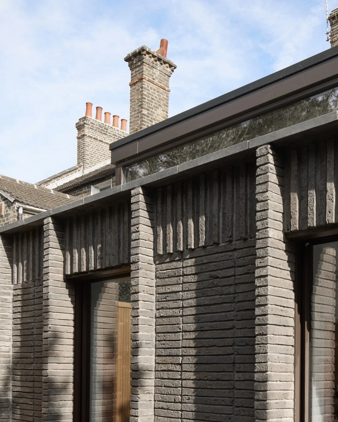 UP AND OVER

The extension is built in a long format dark brown brickwork, designed to blend with the darker London stock bricks of the original house, but also create a legible addition to the building. Slim piers are formed at the window openings t