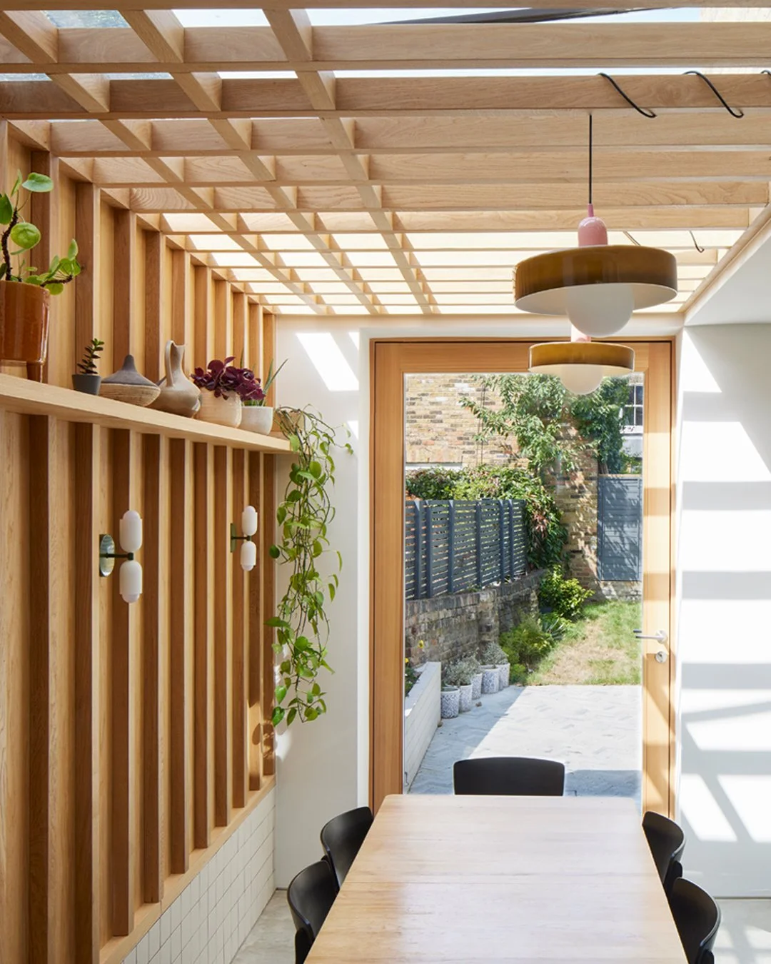 TIMBER &amp; TILE

Inside the dining room, the glazed roof over the side return is paired with a solid oak screen beneath, filtering daylight while reducing overlooking from neighbouring upper-floor windows. The internal wall is finished in oak panel