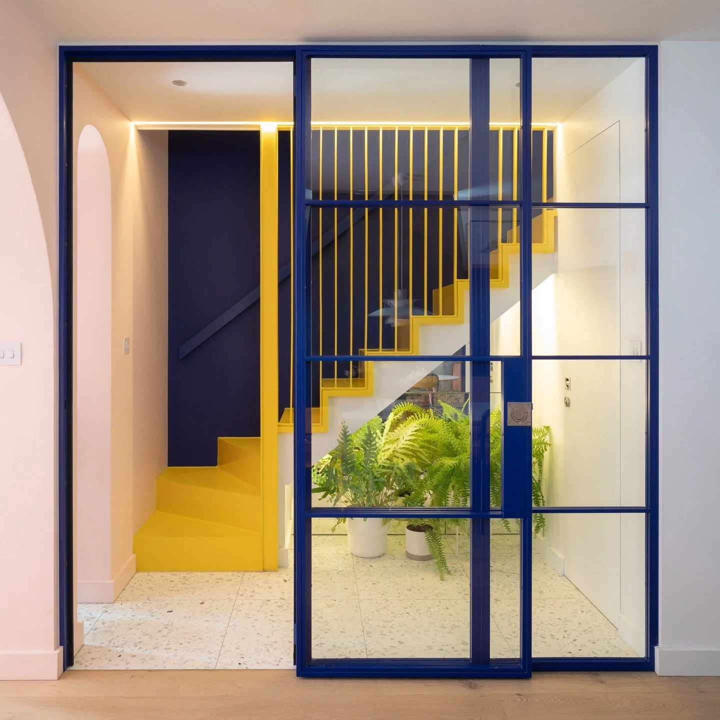 Vivid House 🌈 

A new staircase was introduced as a seamless continuation of the original stair connecting the ground and upper floors. Reimagined as a minimalist take on the Georgian stair, it announces itself at ground level with an arched steel n