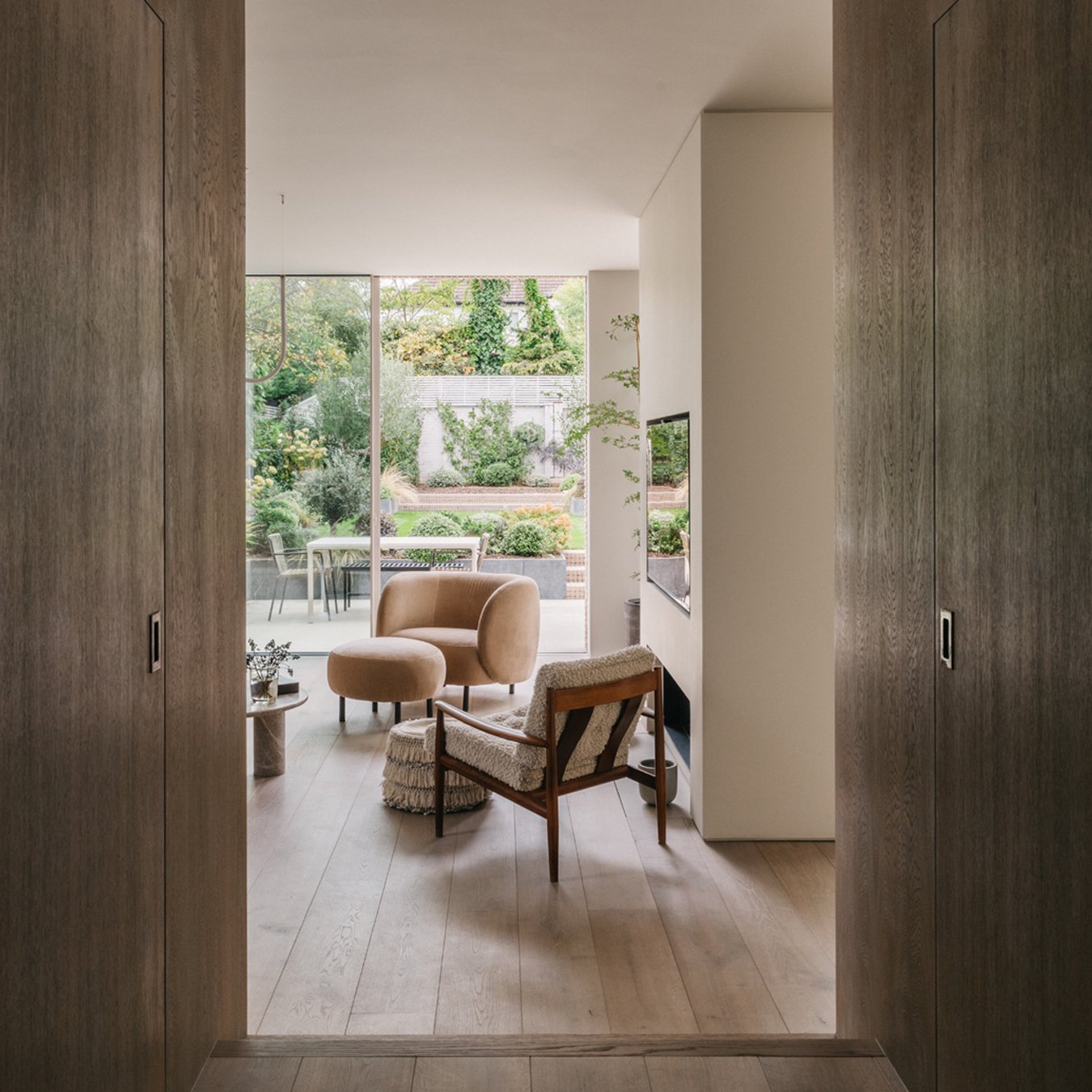 SUBURBAN HOUSE

The entryway into the rear living spaces is via dramatic double oak doors, folding back to be concealed within a chamfered joinery volume that acts as the delineator between the softer more traditional detailing of the house beyond an