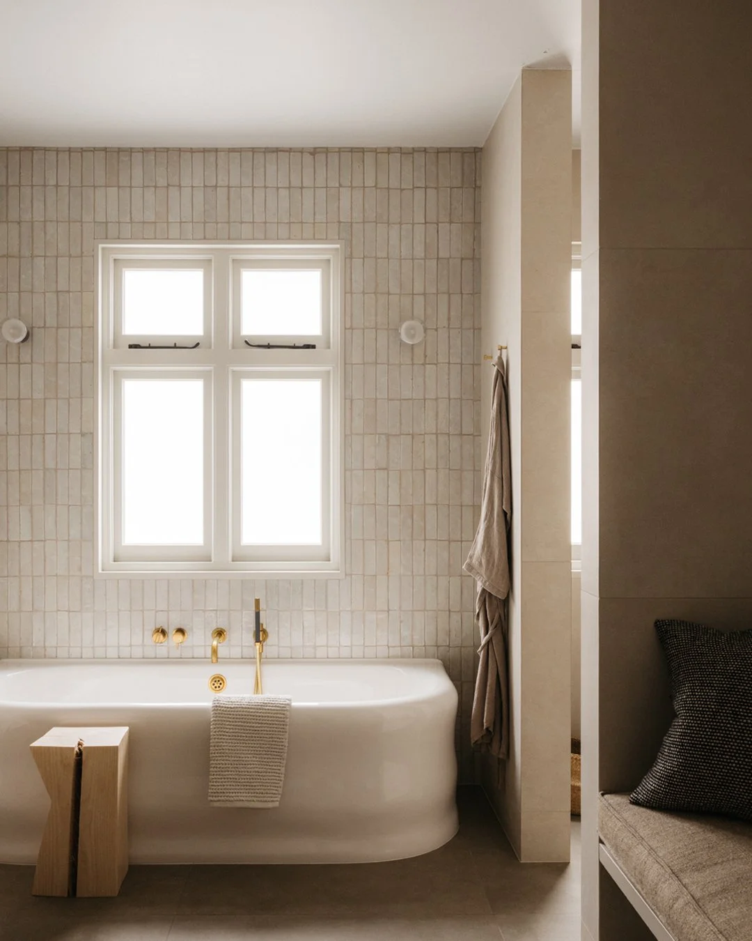 SUBURBAN HOUSE

The en-suite bathroom combines glazed handmade tiles with large format porcelain to continue the theme of a calm, modern, yet soft and textured interior aesthetic. A double vanity unit and steam room sit within the sort of spacious ar