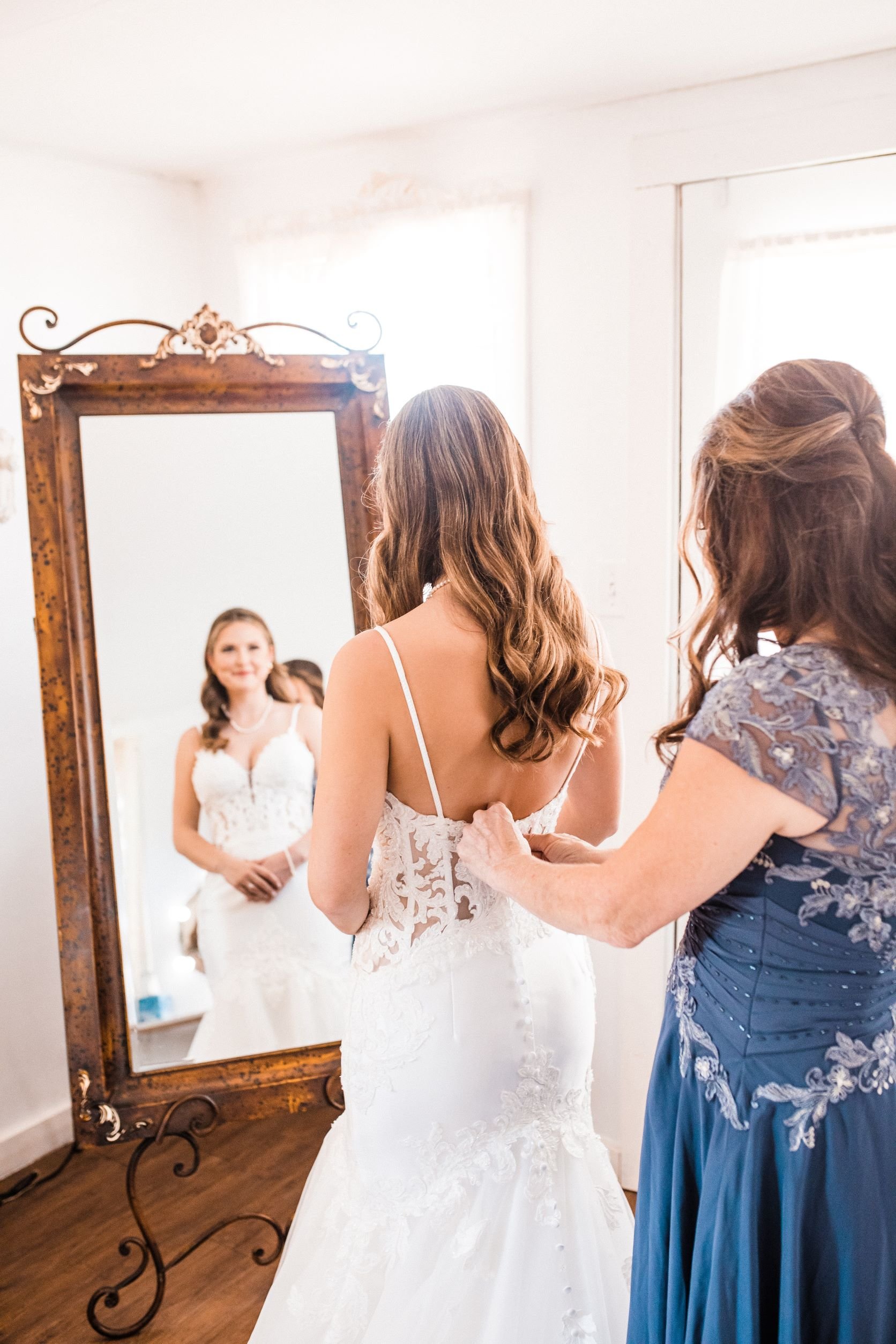1Z8A0160 -Resized-Haley & Brain - Haley in front of mirror w mom helping w bridal gown.jpg