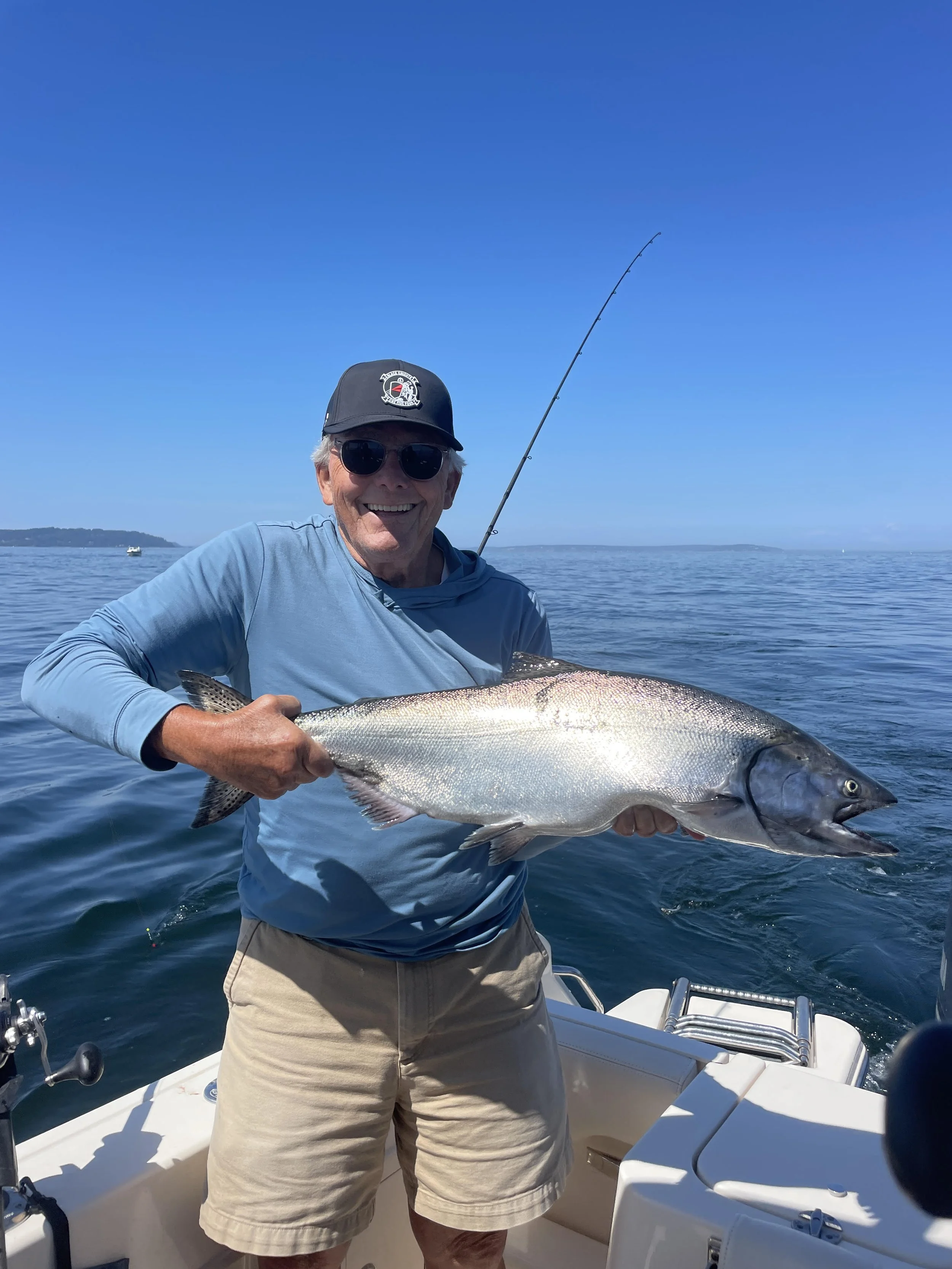 A man holds a chinook salmon he just caught on wind knot guides salmon charter