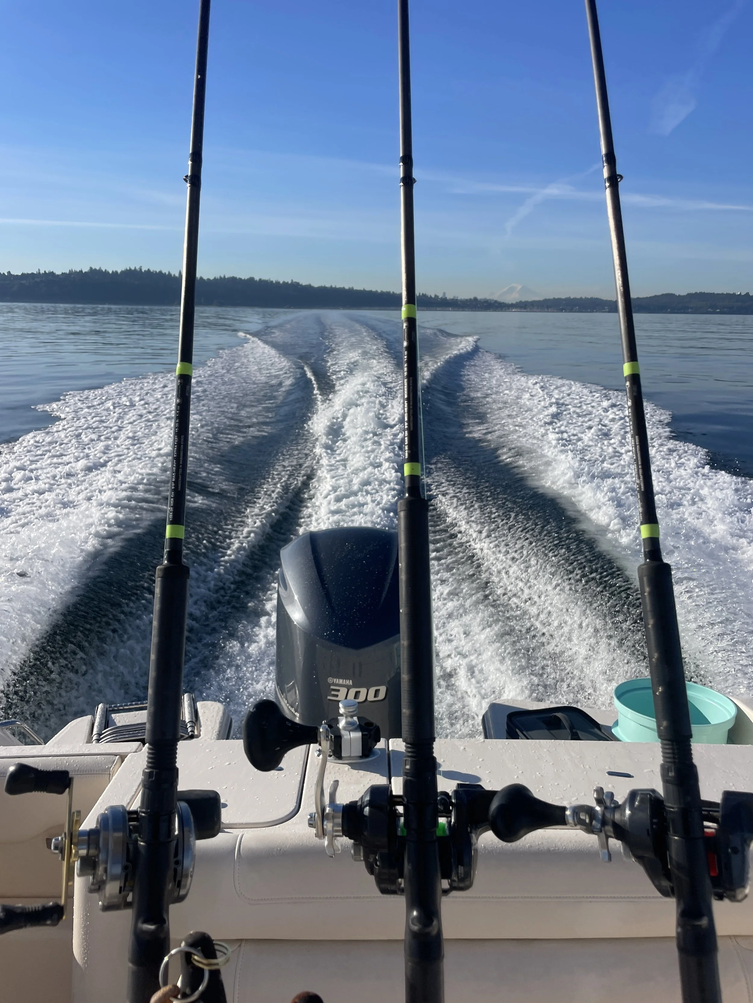 a view from the stearn of a grady white center console.  Shimano rods are reels are in rod holders.  the boat wake is stunning
