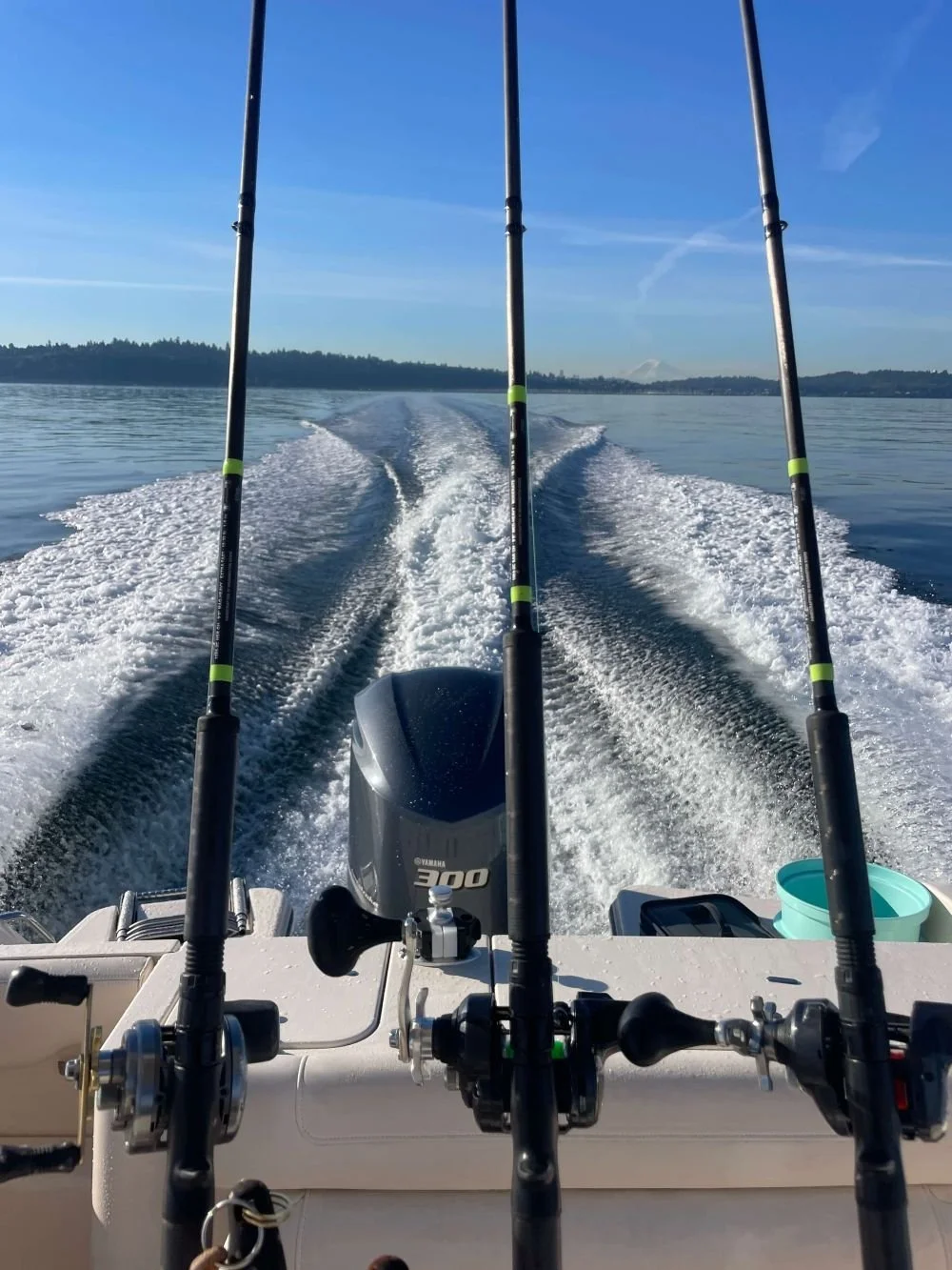a view from the stearn of a grady white center console.  Shimano rods are reels are in rod holders.  the boat wake is stunning