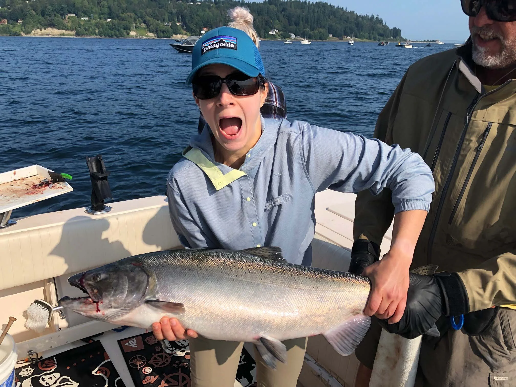 A women holding a chinook salmon she caught on salmonseattle.com charter boat
