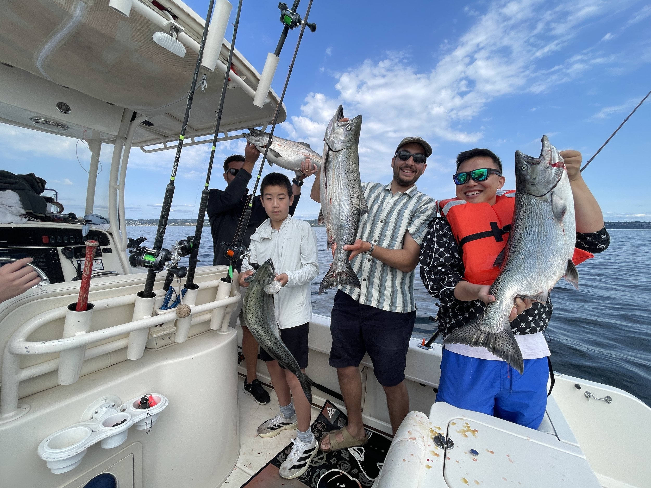 A group of Seattle Charter boat anglers proudly presenting a limit of hatchery Chinook Salmon with fishing Shilshore Marina Charter Boat