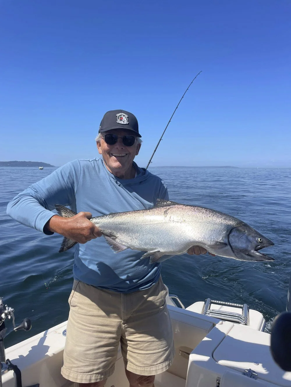 A  man holds a freshly caught Chinook Salmon on www.salmonseattle.com charter boat