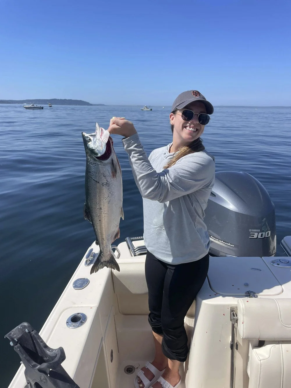 a women posing with a fresh caught silver salmon on wind knot guides seattle fishing chater