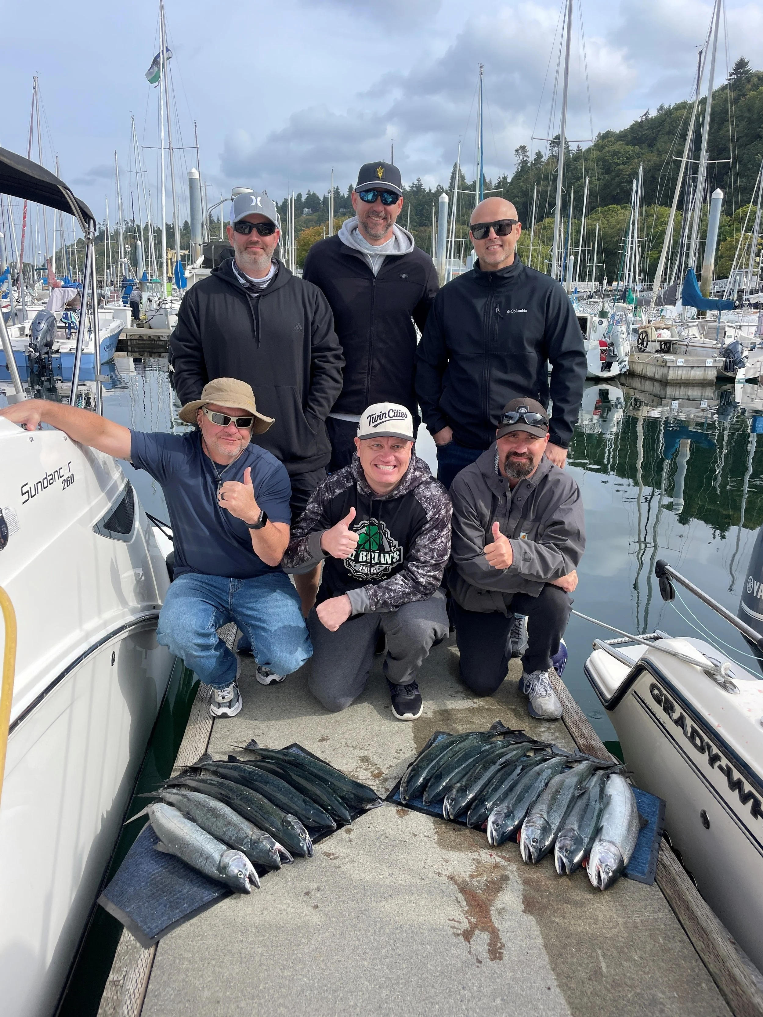 A group of men posing with freshly caught coho salmon while fishing with Wind Knot Salmon Guides.  Seattle, Washington 9/19/2026