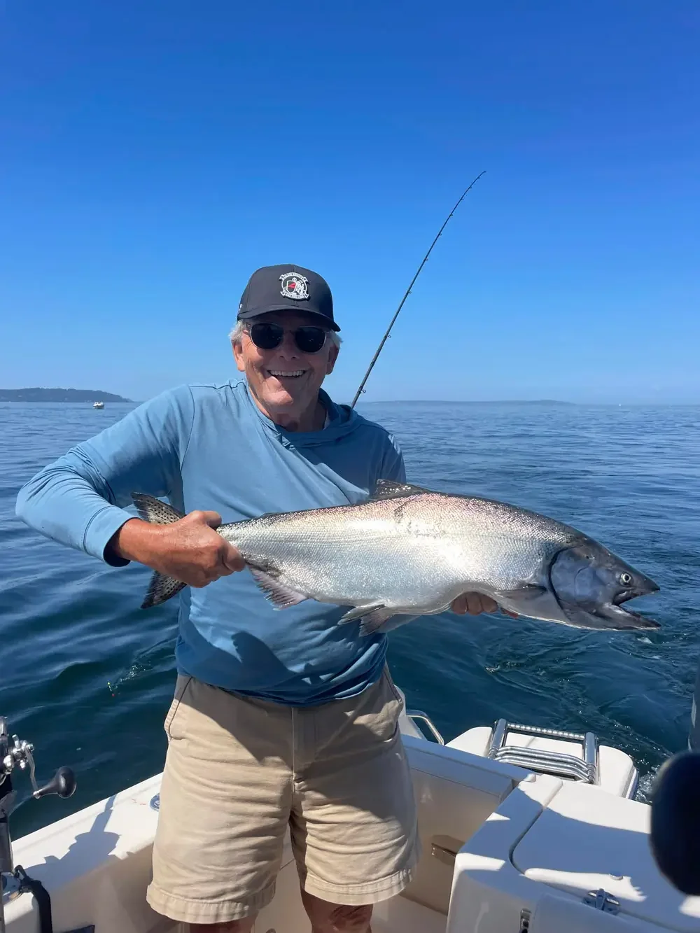 a man poses with a chinook salmon caught near seattle on wind knot guides charter boat