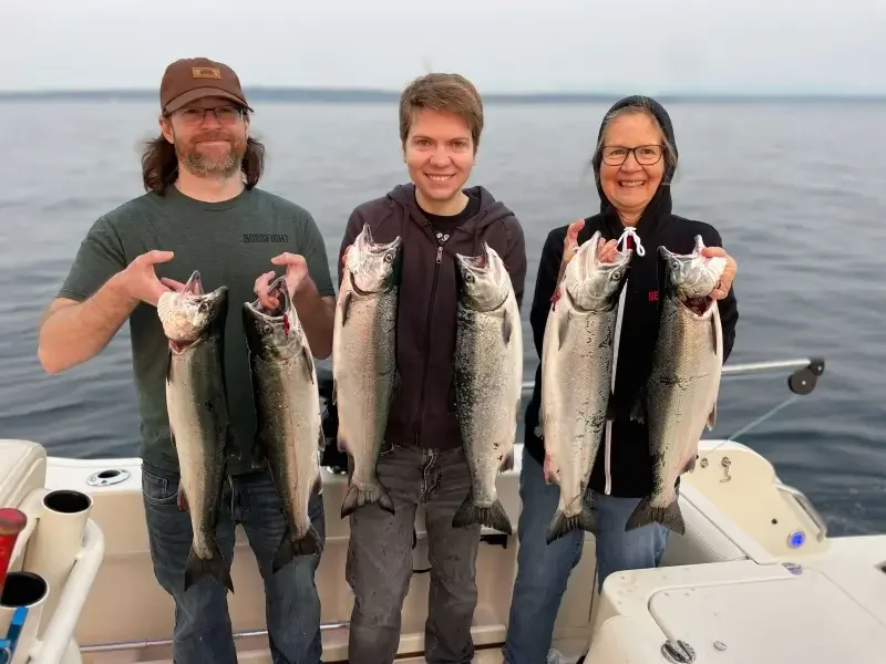 A mother and children holding a limit of coho salmon with fishing with Wind Knot Guides