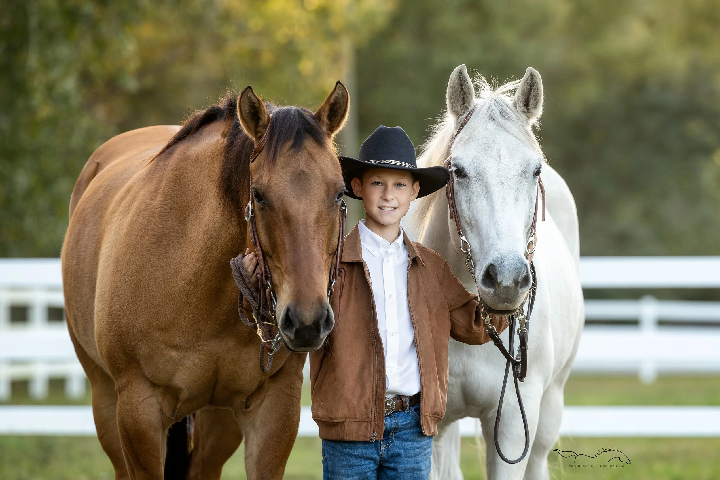 boy standing between his two horses