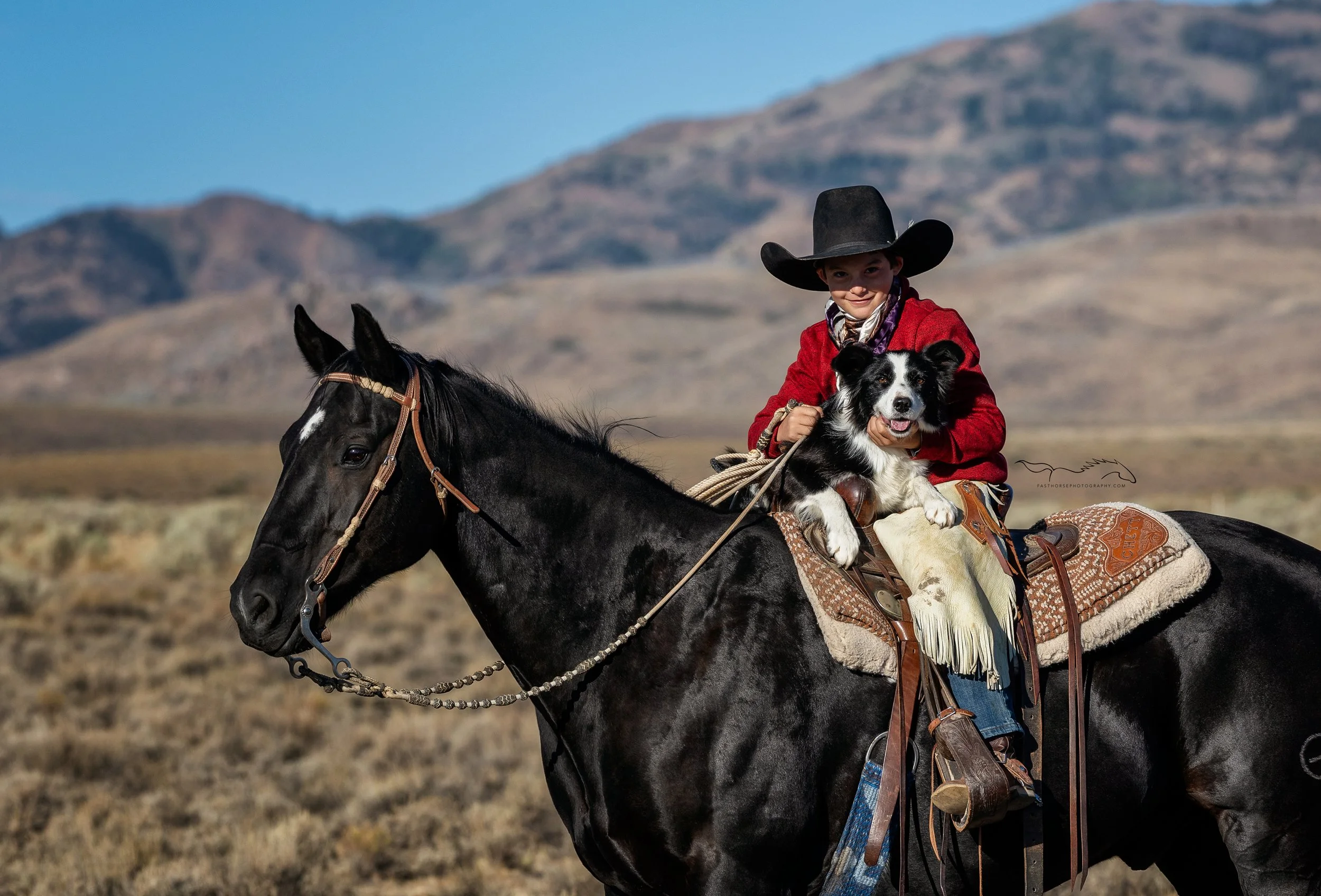 tween boy sits on his horse with his dog in his lap
