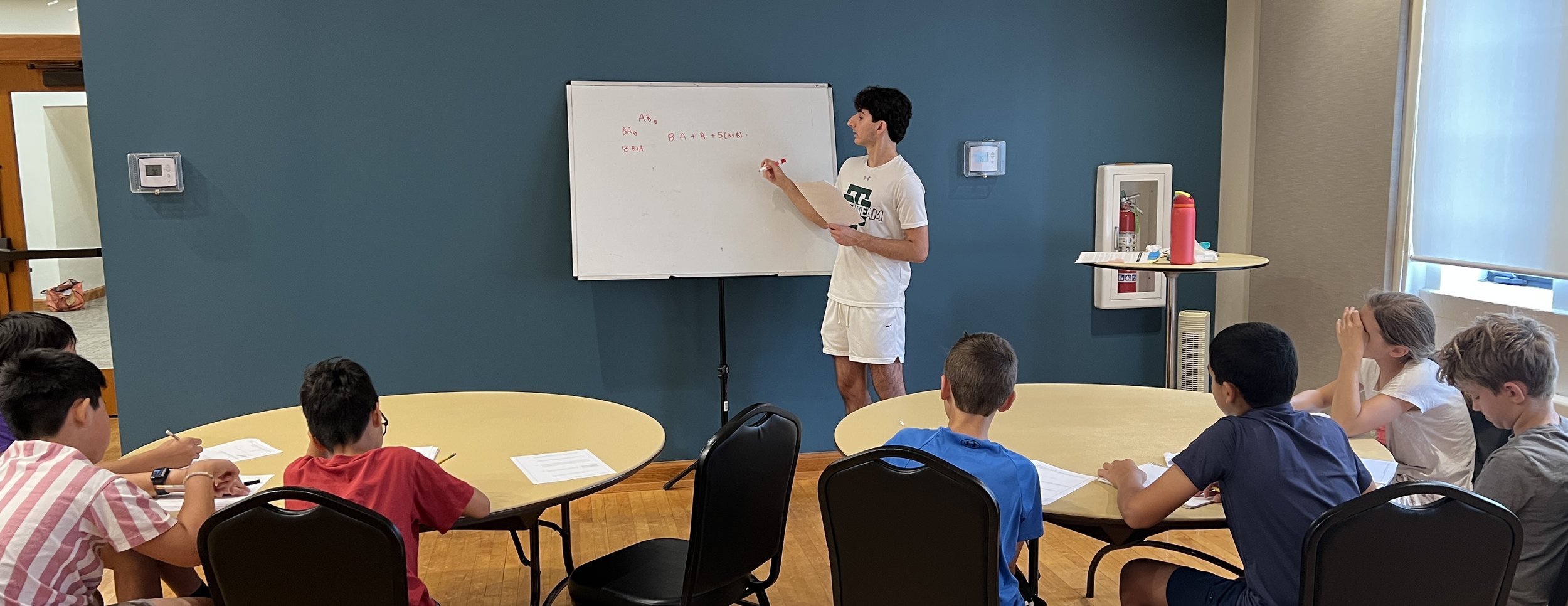 Students working on math problems at Kids Inspire Kids Math Circle