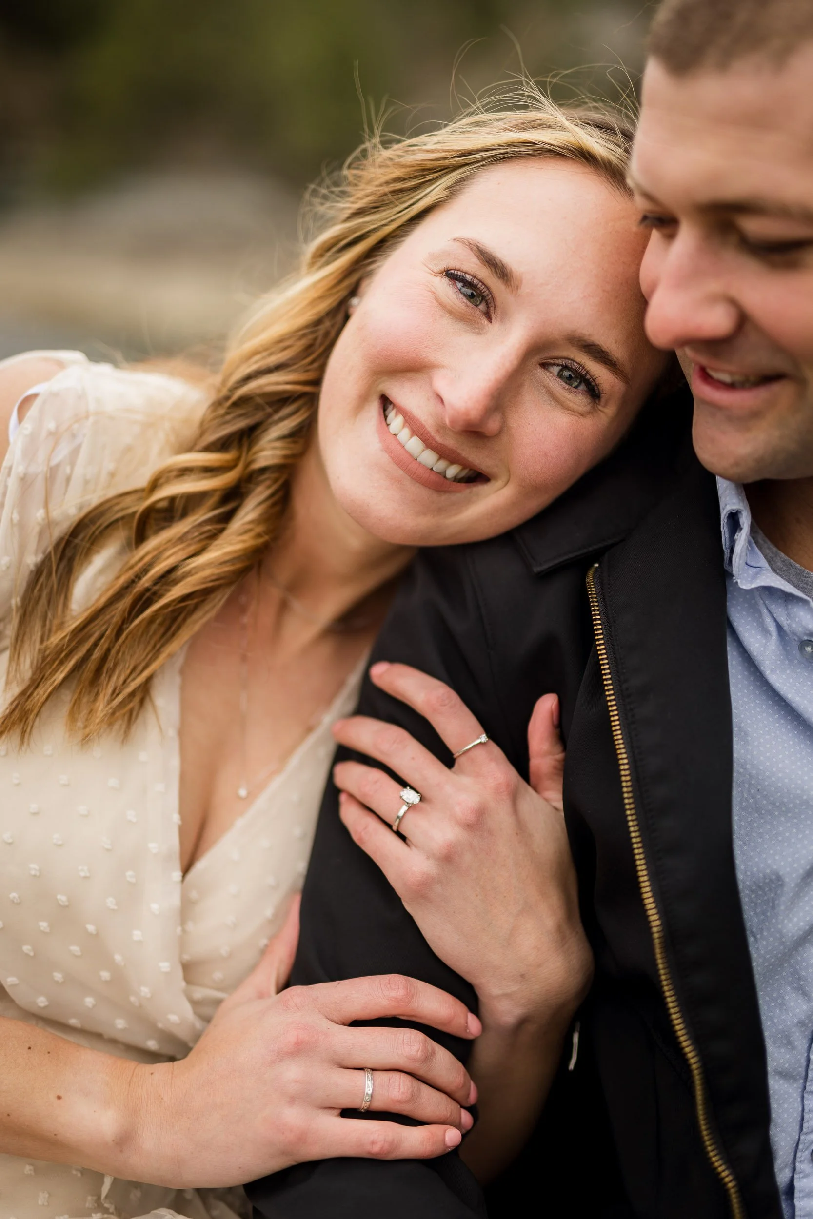 Engagement photo of couple holding each other with bride looking at the camera