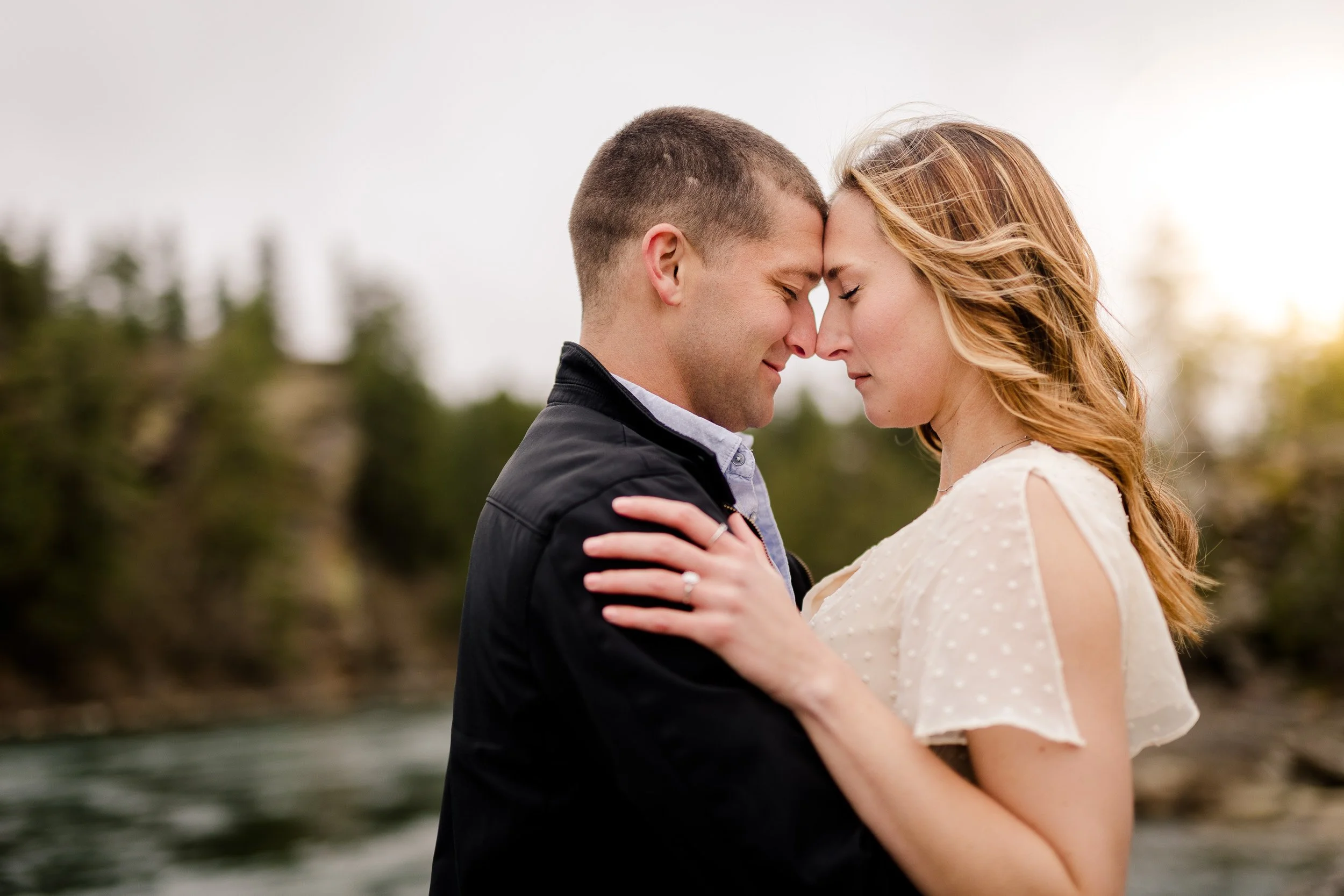 Engagement photo of couple holding each other close with eyes closed