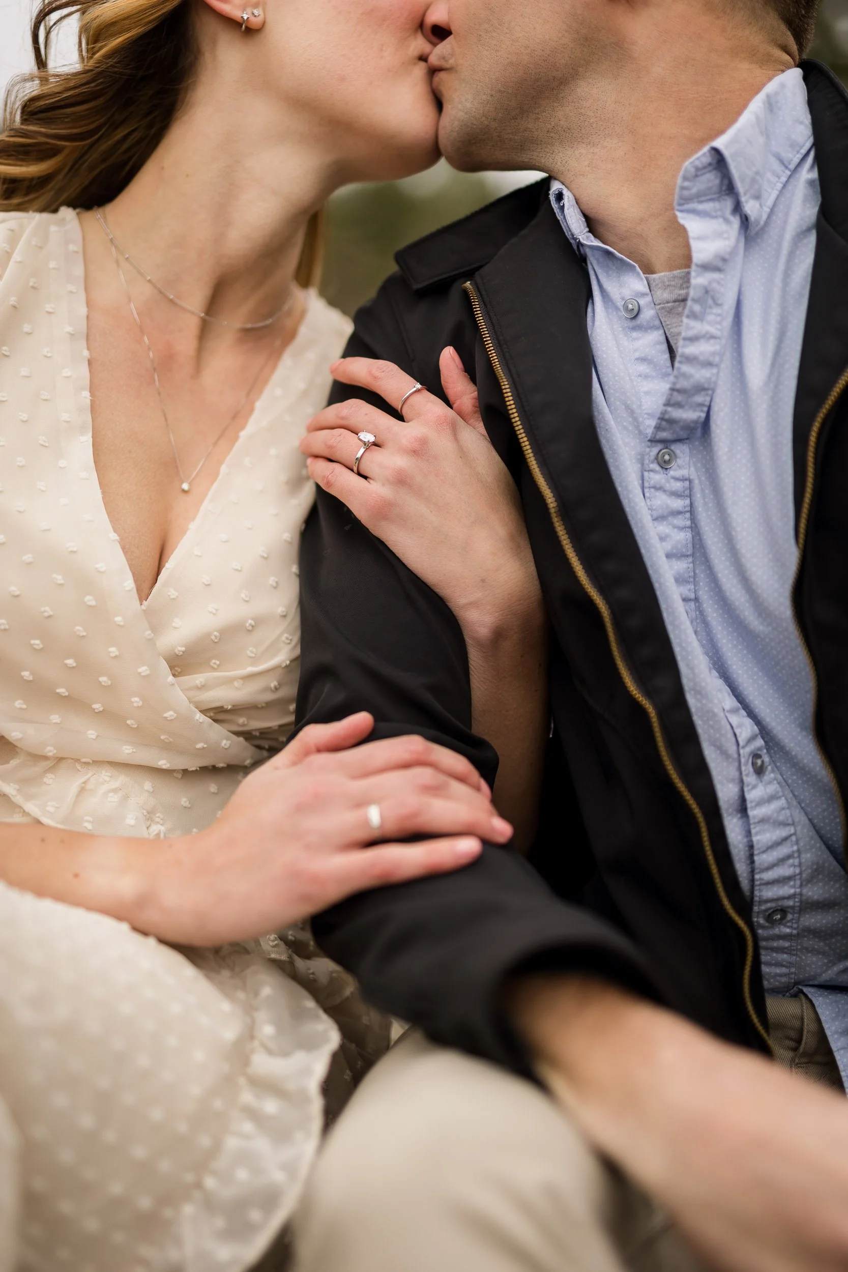 Couple kissing with ring while sitting down