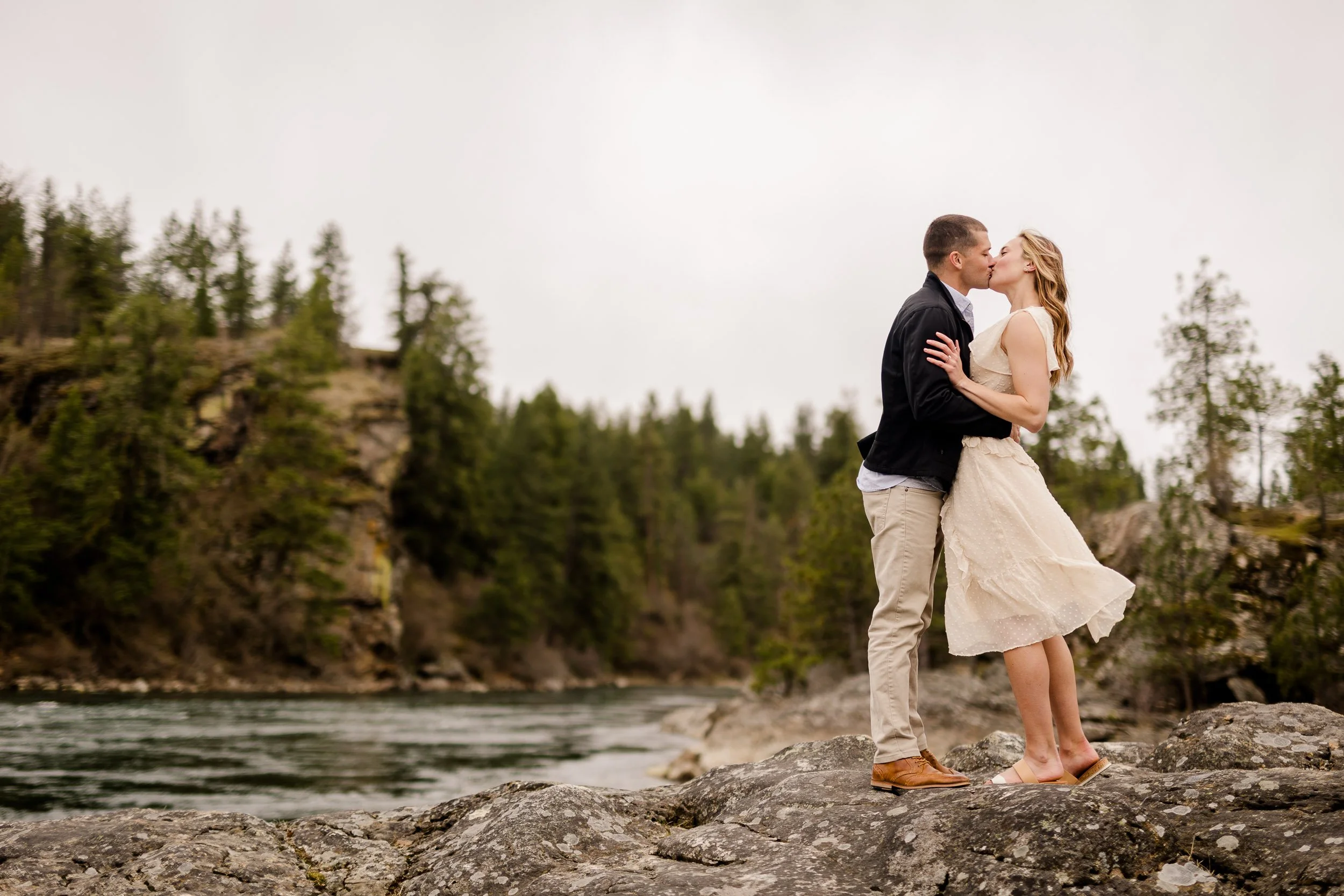Couple kissing on top of a rock
