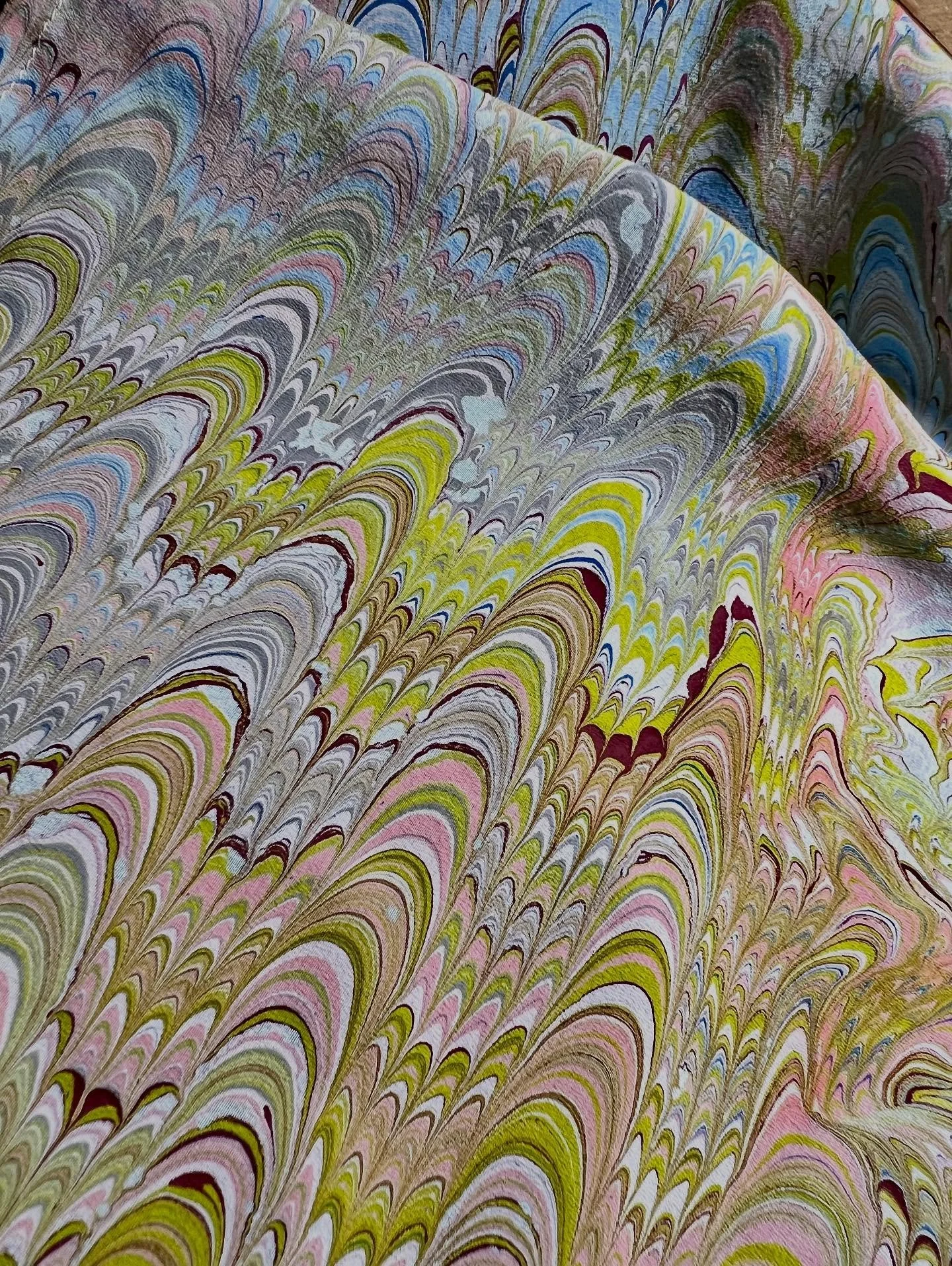 I marbled silk fabric for the first time today. The first two images show pieces of silk that started out as dusty blue, and the third image shows three pieces of white silk after the marbling process.