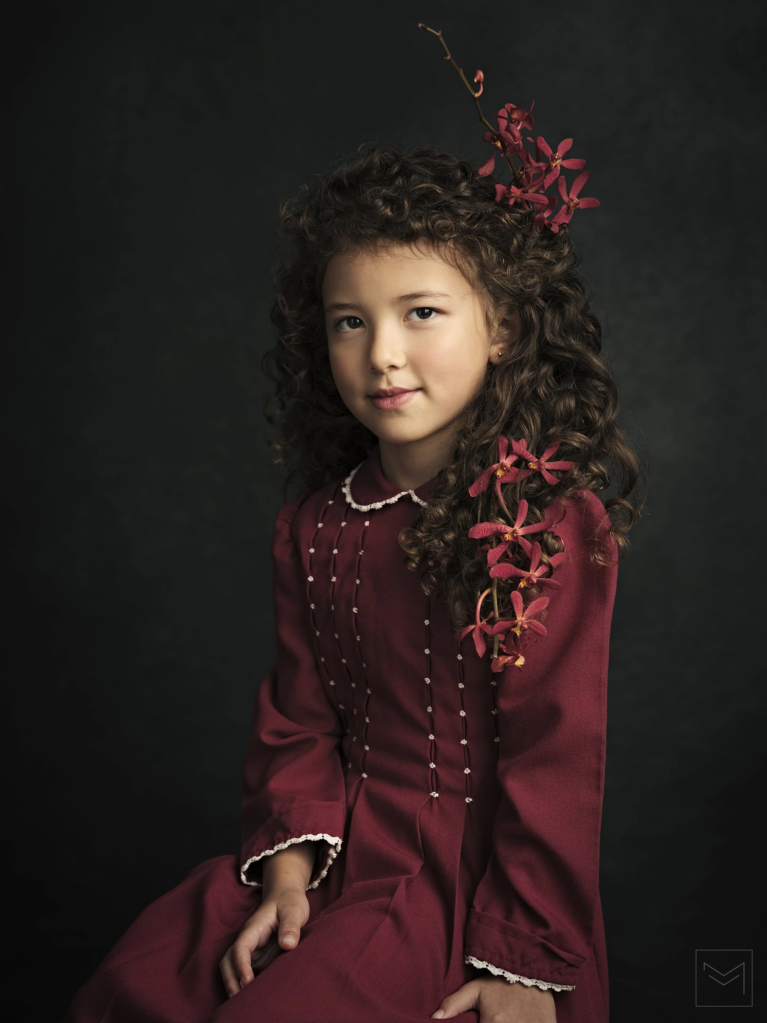 Colour childrens portraiture of young girl in a vintage red dress with red flowers in her hair