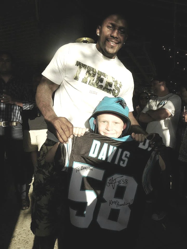 Thomas Davis of the Carolina Panthers stops by the Roaring Riot event to surprise Braylon with a jersey and donation