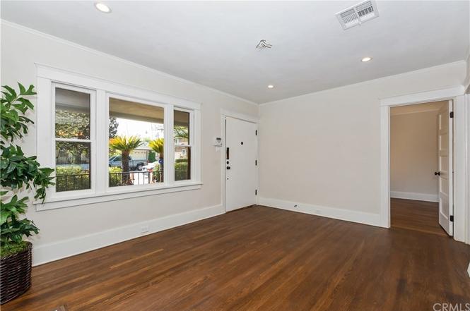  212, view from fireplace back to living room and front door, c. 2018-2019. Windows look out onto front porch. 