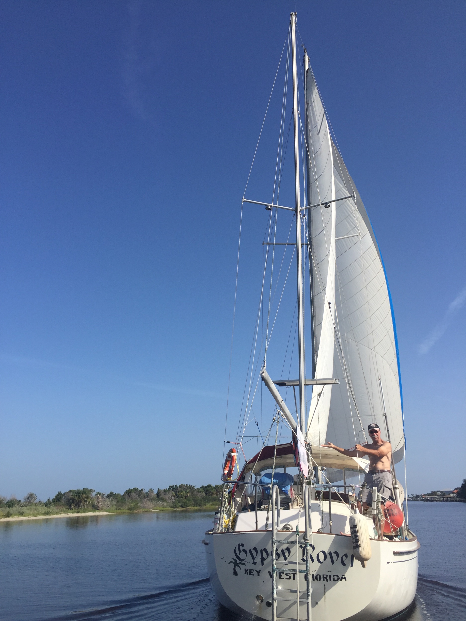 First mate, Grandpa Mike, near Merritt Island, FL trimming some sails while traveling north on the ICW.