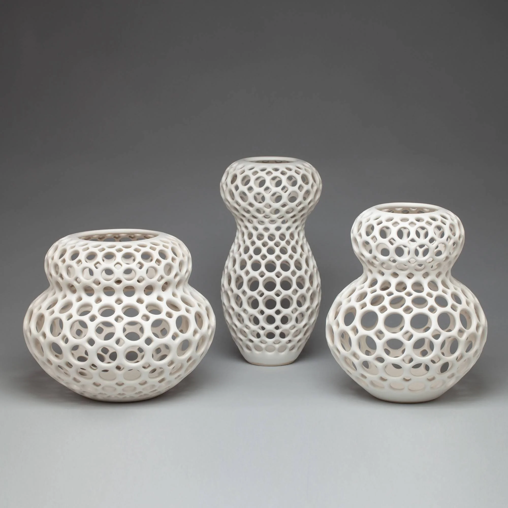 Trio of white pierced tabletop sculptures in the Femme Collection