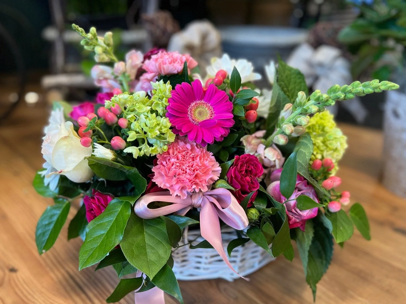 A gorgeous Mother's Day Basket filled with Pink Gerbera Daisies, Green hydrangea, carnations, snap dragon, roses and greens