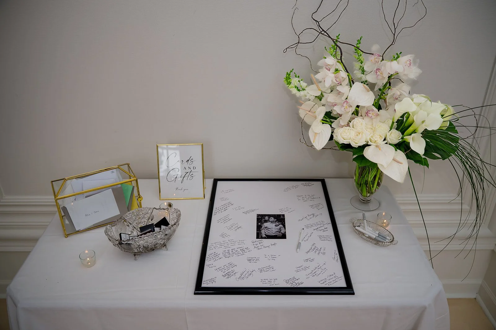 White Orchids, anthurium, and snap dragon flower arrangement on wedding gift tables