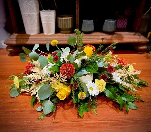 Modern Thanksgiving centerpiece designed for an oval or rectangular table filled with fresh fall flowers, colors and greenery.