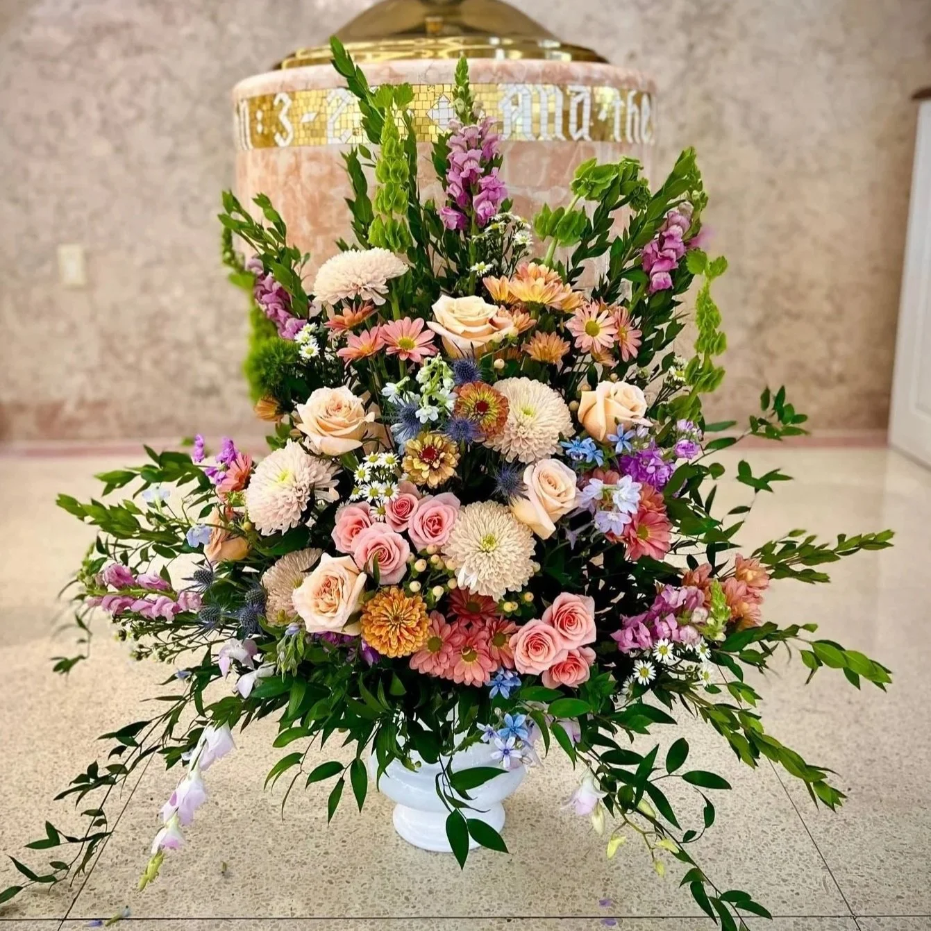 Accents by Michele Flower Studio and Flower Delivery have the best funeral flowers in Newtown Square. This picture is of a beautiful pastel flower arrangement designed in a white urn.