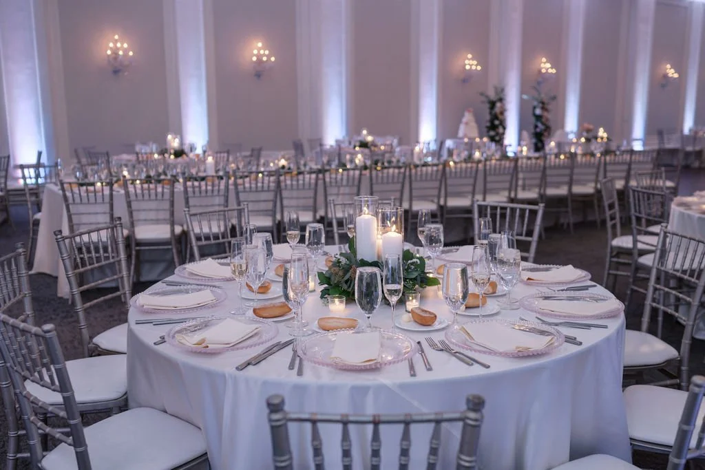 Pillar candlestick trio surrounded by greens on round table