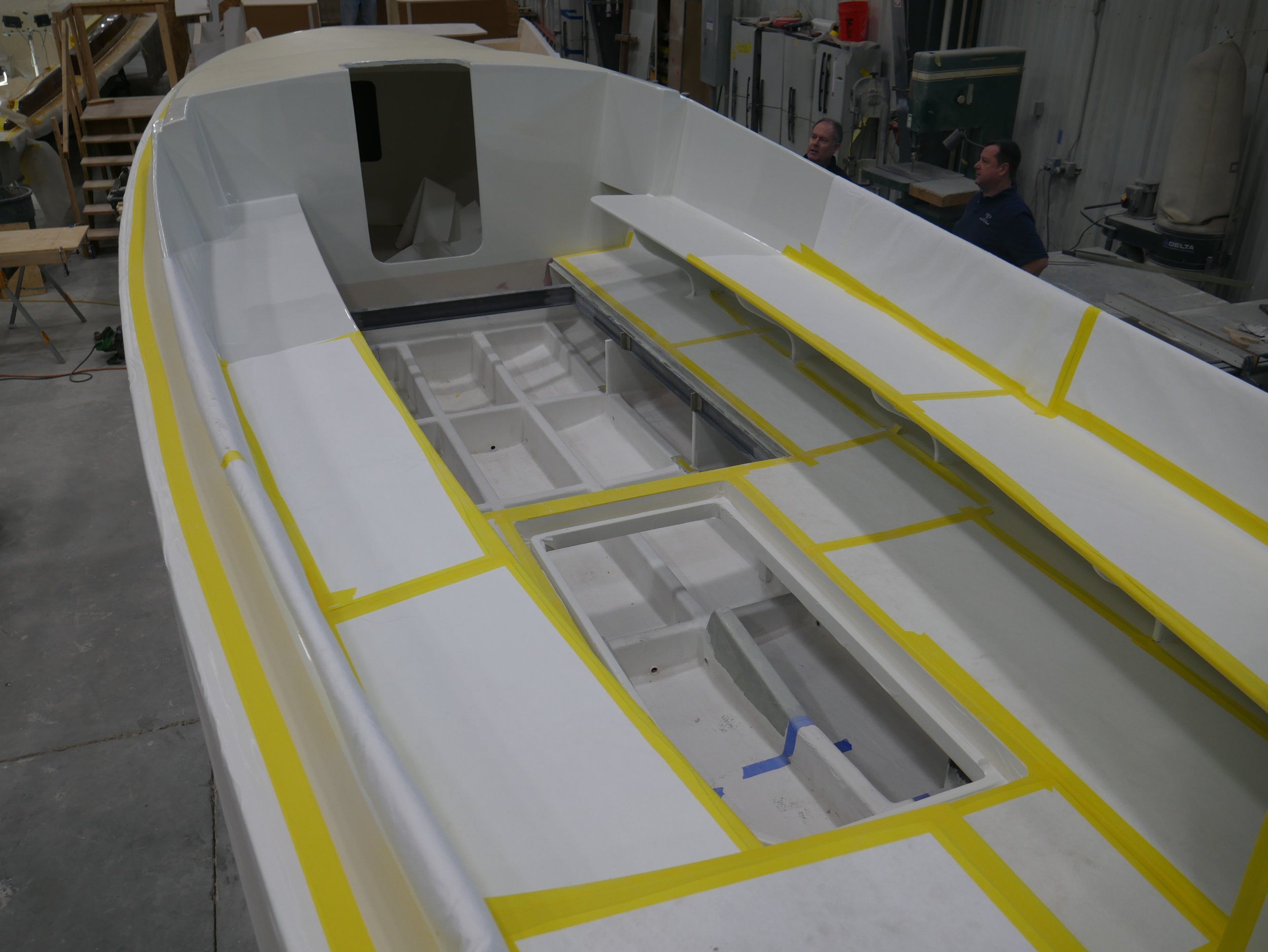    Boat cabin showing below deck areas where the HV battery set and motor will go.&nbsp; The bench seats will accommodate life jacket storage underneath.&nbsp; The yellow tape is securing felt paper to protect painted areas.   