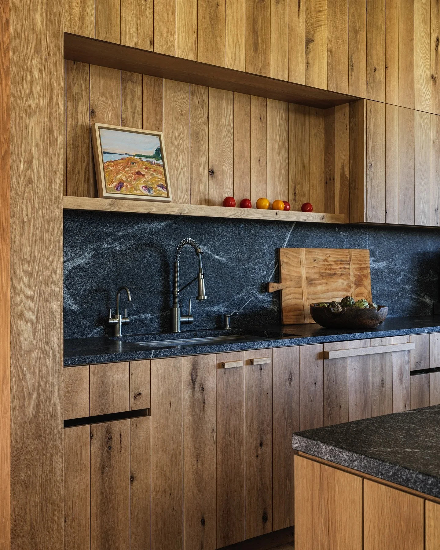 &ldquo;White oak reigns in the main room, where cabinets flank a central wood stove... The oak finish also complements the subtle stain of wide-plank floors that span all but the mudroom, where speckled terrazzo defends against all of Vermont&rsquo;s