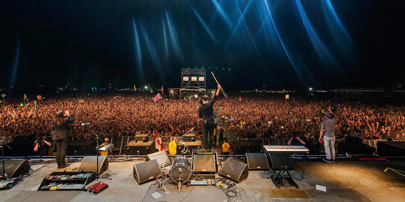 mumford and sons playing to large crowd outdoors.jpg